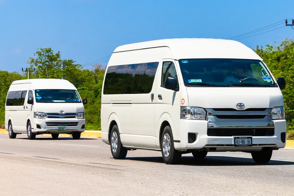 Two clean work vans in different lanes on the road, both in perfect condition after being maintained by the Motor Works Group