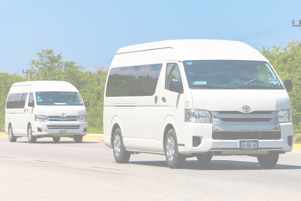 Two clean work vans in different lanes on the road, both in perfect condition after being maintained by the Motor Works Group