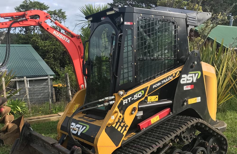 Track loader used for levelling ground, digging trenches, lifting pallets and raking dirt