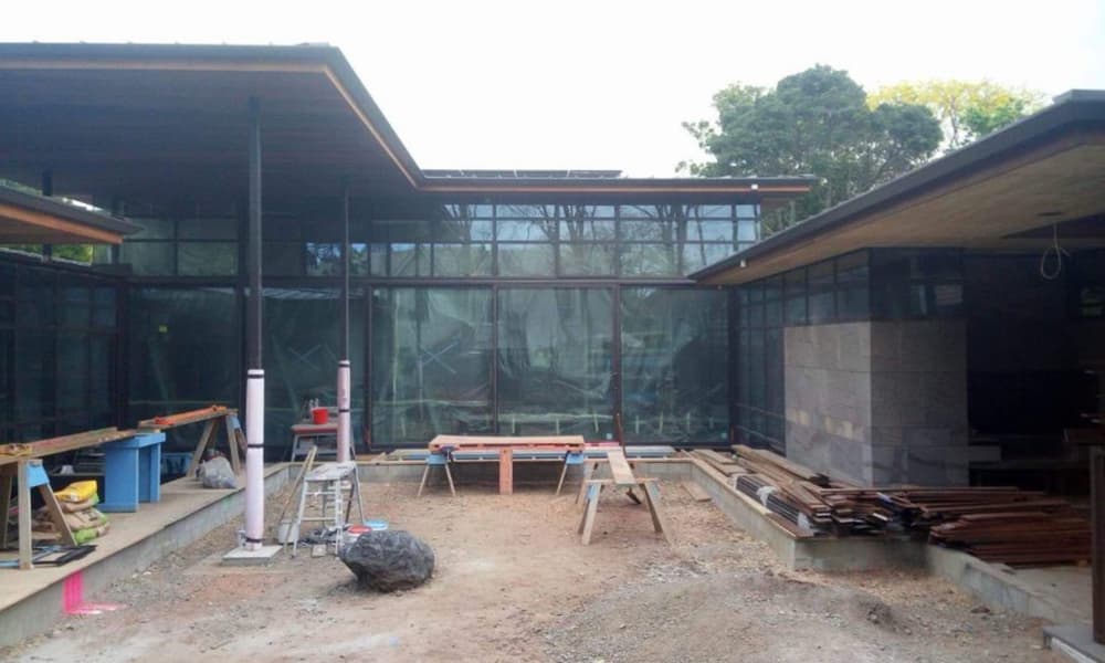 Modern new build house in its early stages with a trickily excavated courtyard and a bunch of workshop benches and materials