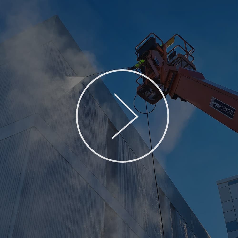 GR Abseiling using a cherry picker to power wash the exterior side of a commercial building