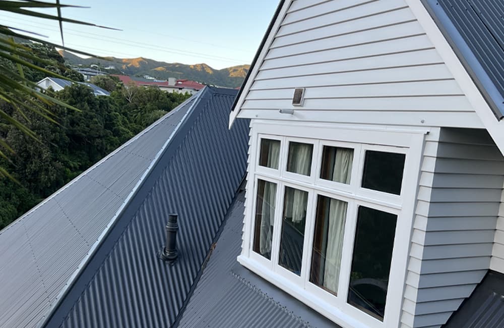 Second story exterior of a flawlessly painted white house overlooking the hills of Wellington