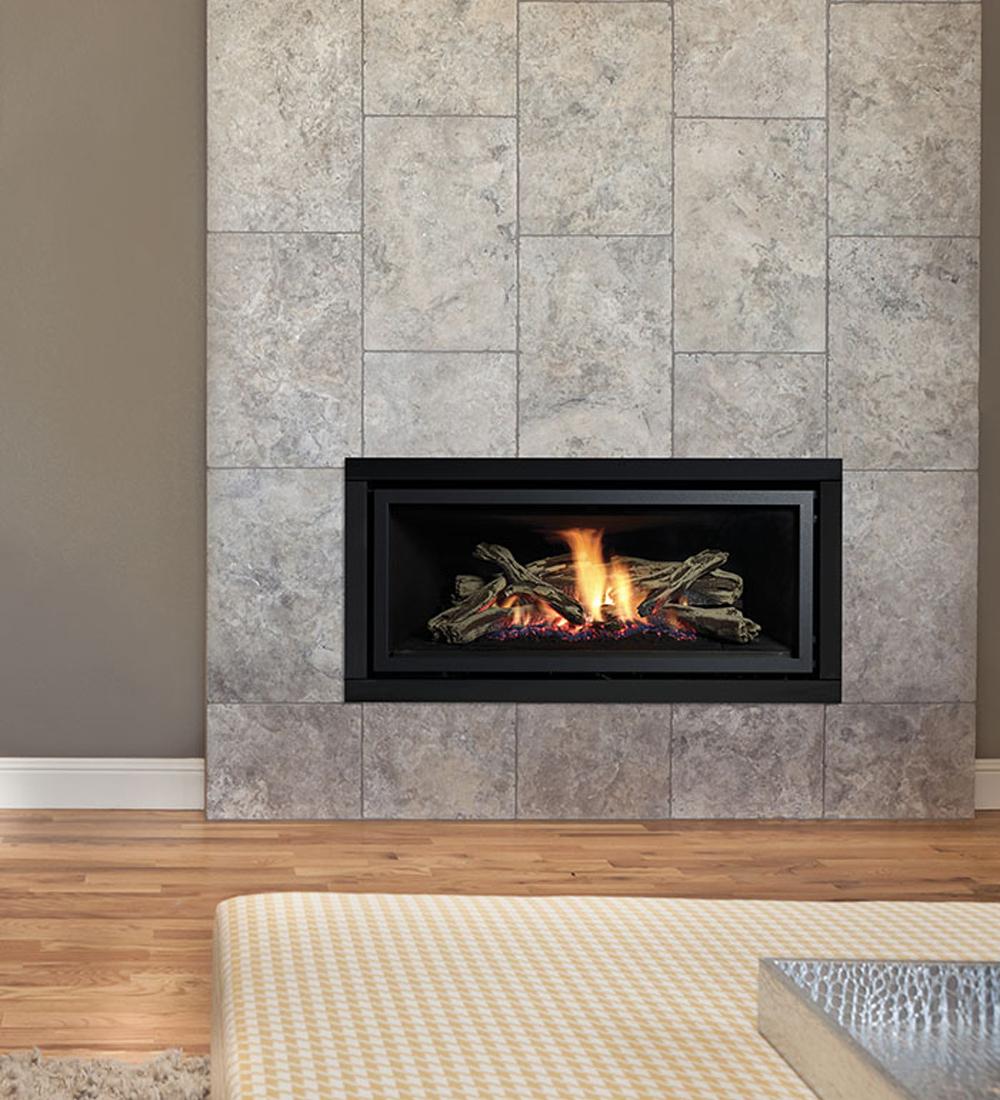 Lit black inbuilt gas fire with a stone tile frame in a room with grey walls and light wood floors