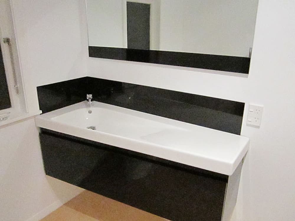 Floating bathroom basin with a black splashback that matches the drawer