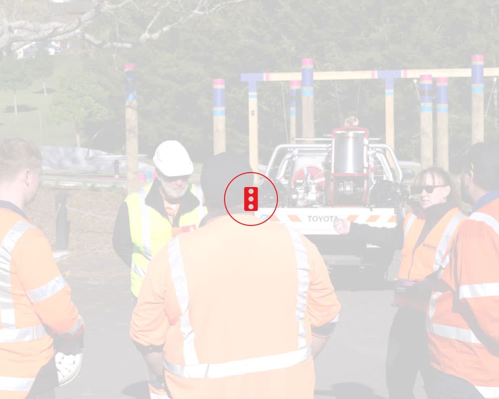 Traffic Management Waikato team members parked up at the local park, assessing a situation as they stand in a circle