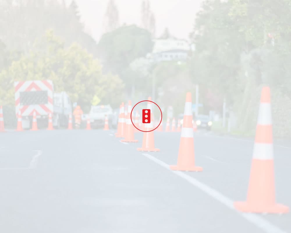 Roadworks vehicles parked up on the street with cones lining the street right down the middle letting cars past
