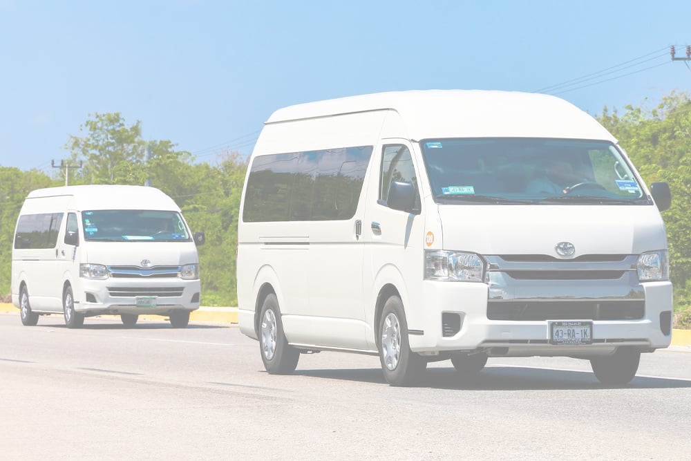 Two clean work vans in different lanes on the road, both in perfect condition after being maintained by the Motor Works Group