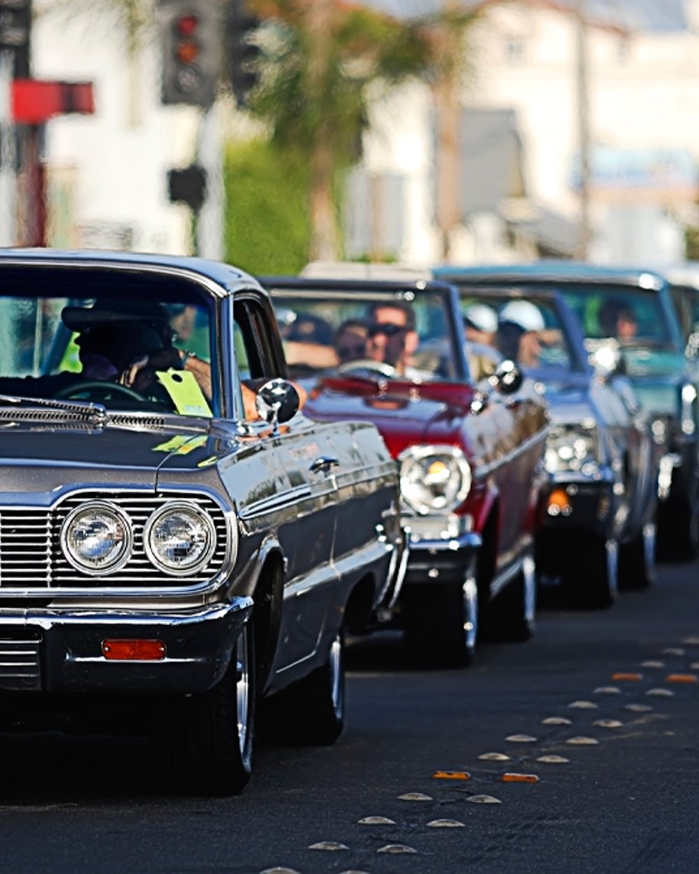 Fleet of classic vehicles lined up on the road at a car show