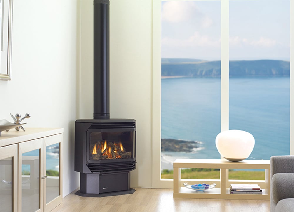 Shiny metallic black log fireplace in the corner of a white living room space with modern furniture