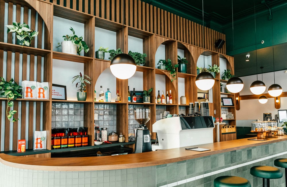 Hood street bistro's wall behind the register, designed beautifully and earthy with wood joinery and heaps of plants