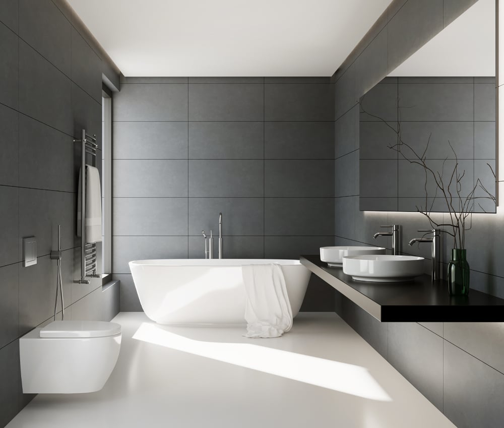 Classic black tiled bathroom with a large white tub, shiny silver fixtures, and a wide rectangular under-lit mirror