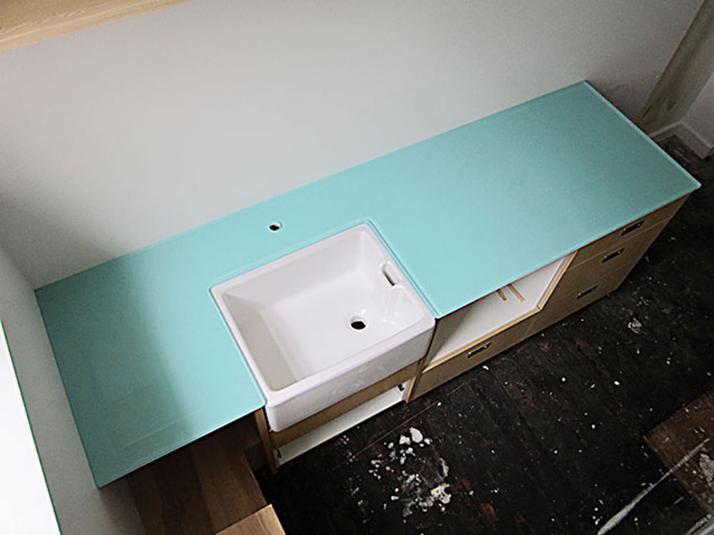 Bathroom with a white farm sink being fitted with a teal countertop