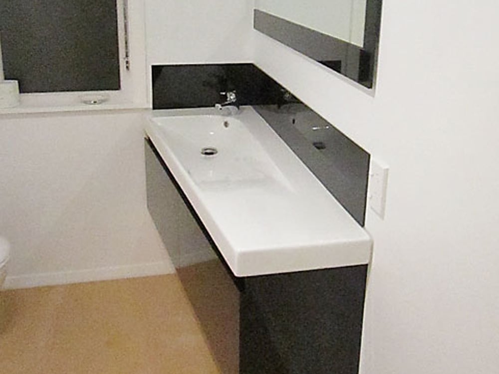 Floating bathroom basin with a black splashback that matches the drawer