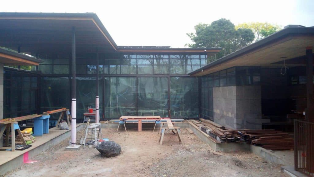 Modern new build house in its early stages with a trickily excavated courtyard and a bunch of workshop benches and materials