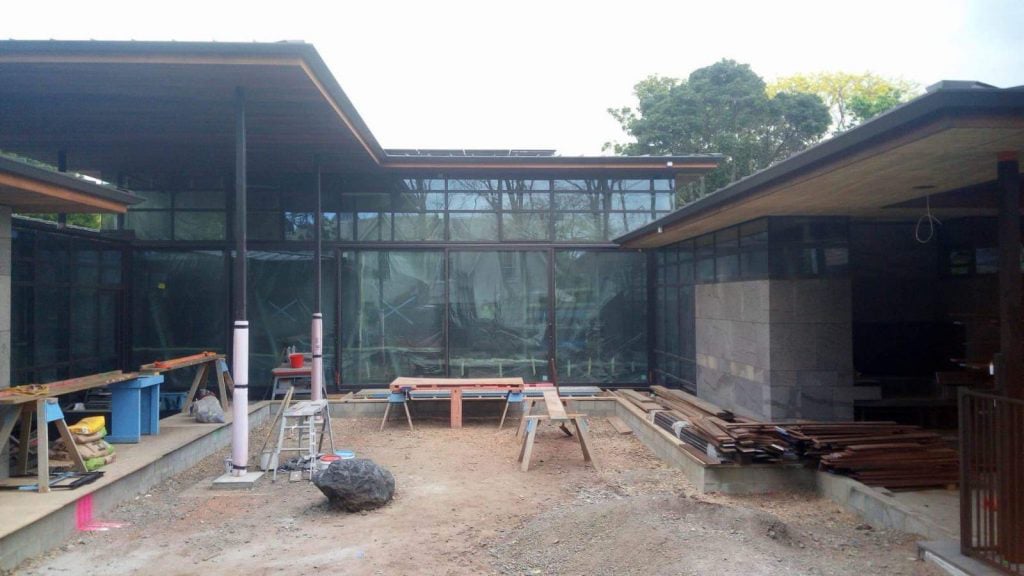 Modern new build house in its early stages with a trickily excavated courtyard and a bunch of workshop benches and materials