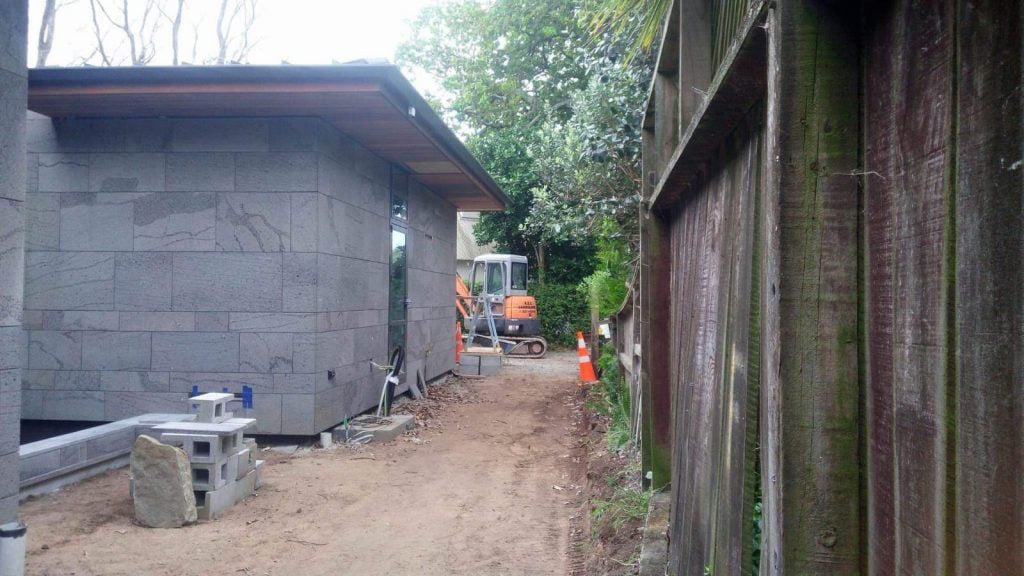  Newly built home with an excavated side lawn being prepared for new soil and grass