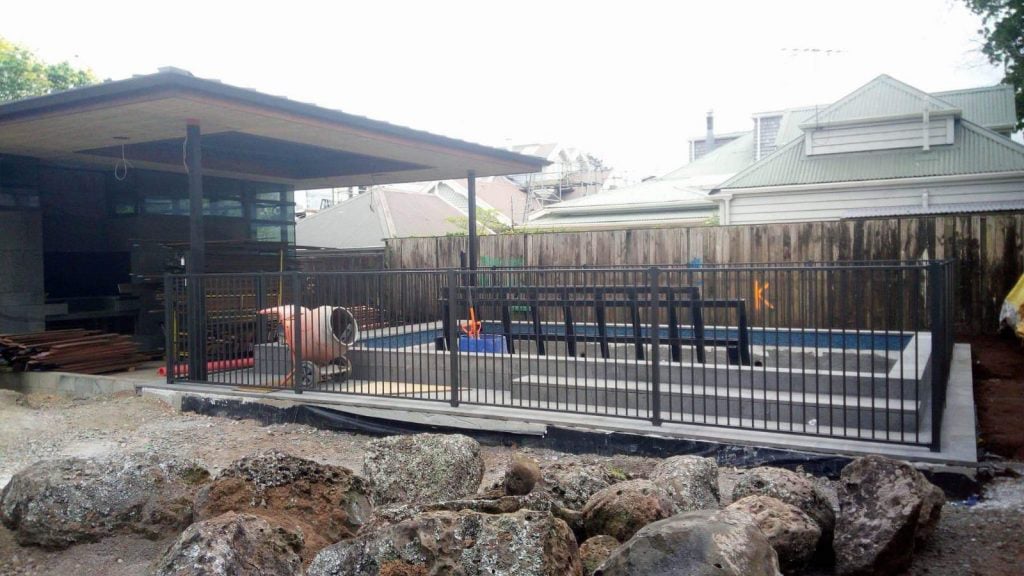 Unfinished backyard with a newly poured concrete pool and an excavated yard ready for new soil and grass