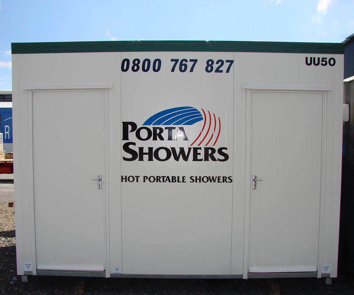 Porta Showers branded portable shower cubicle painted in white with two doors and contact number in large black letters