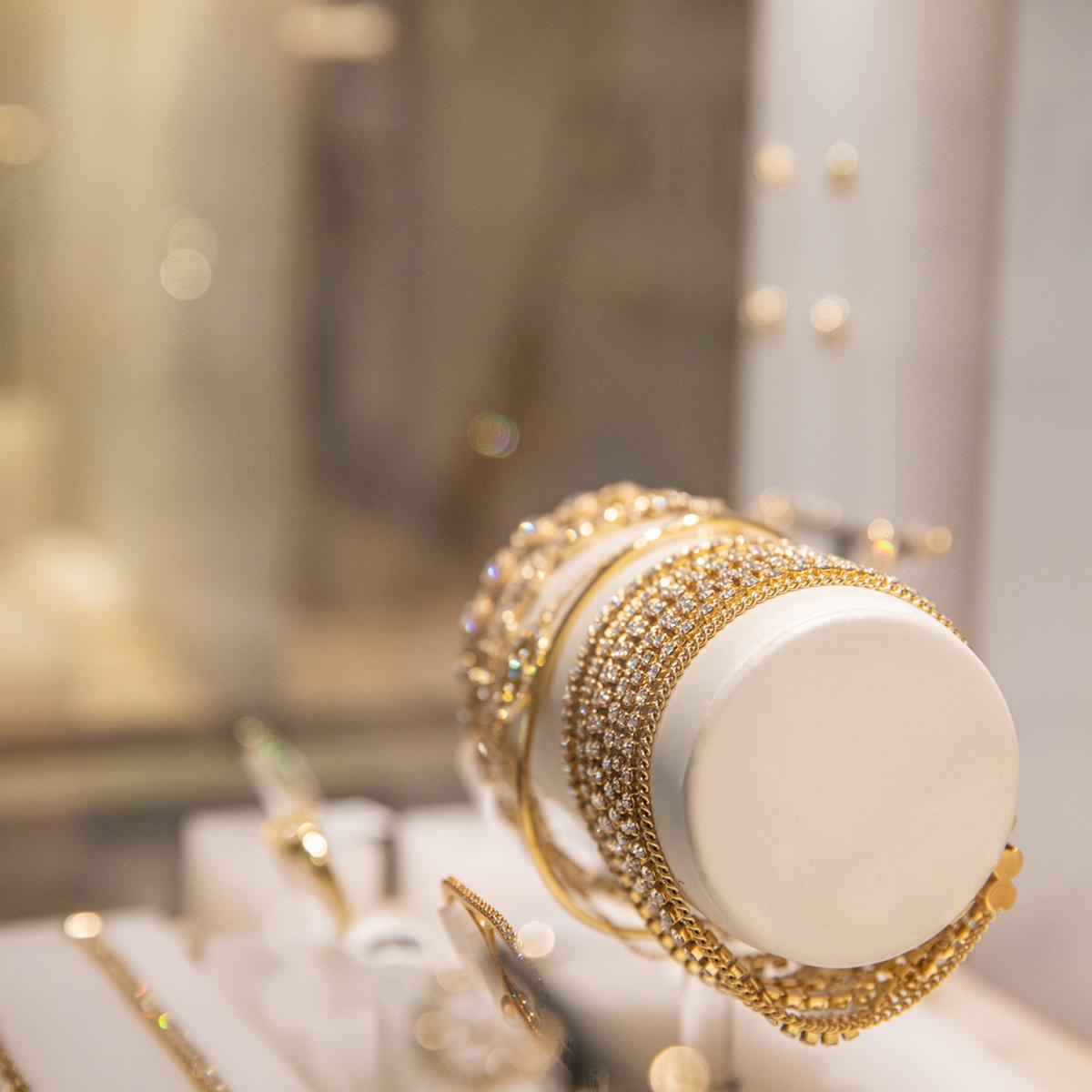 Close up photo of multiple gold diamond bracelets on display in the Hammon Diamond Jewellers Store