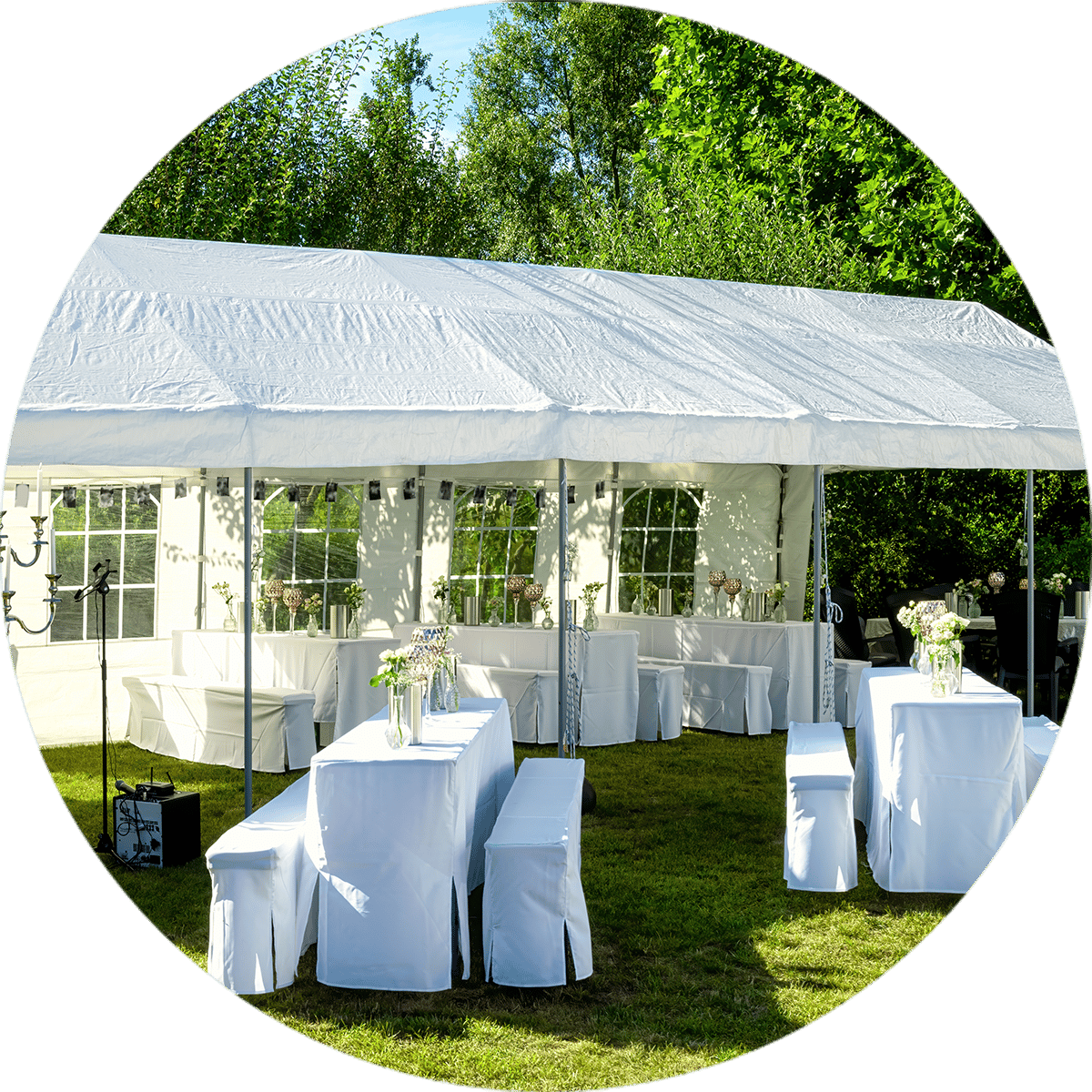 Long white Marquee with Tables and Bench Sets covered in white table cloths set up on the grass with green bush in the background | Hire Marquee Levin