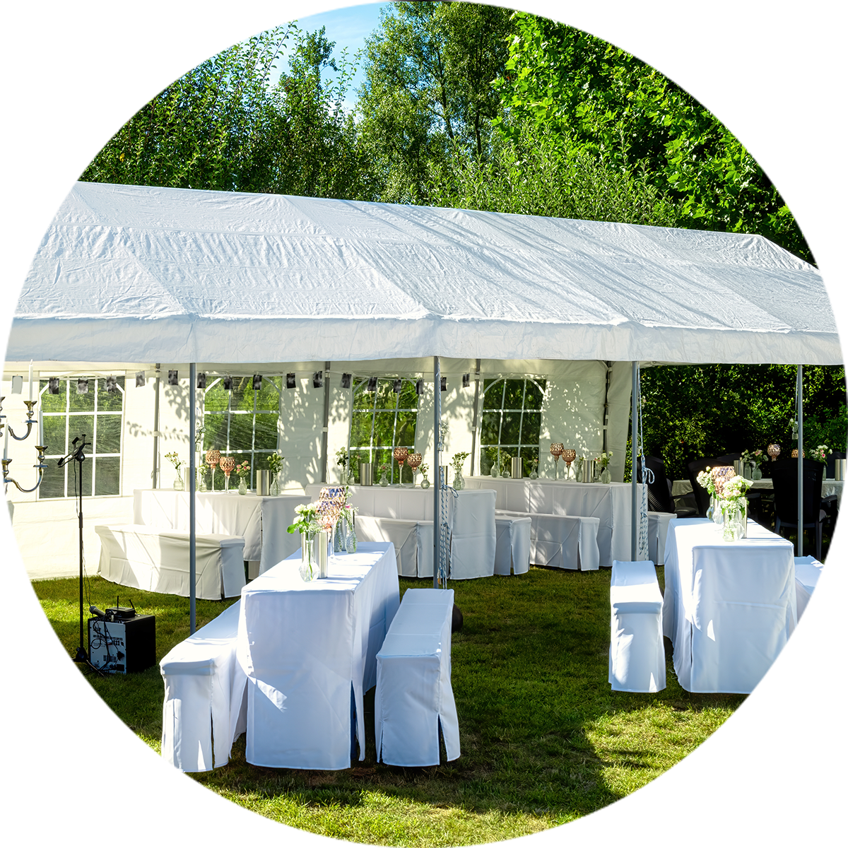 Long white Marquee with Tables and Bench Sets covered in white table cloths set up on the grass with green bush in the background | Hire Marquee Levin