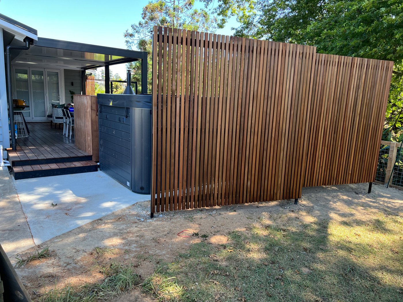 Custom wooden dividers that create privacy for a houses outdoor hot tub