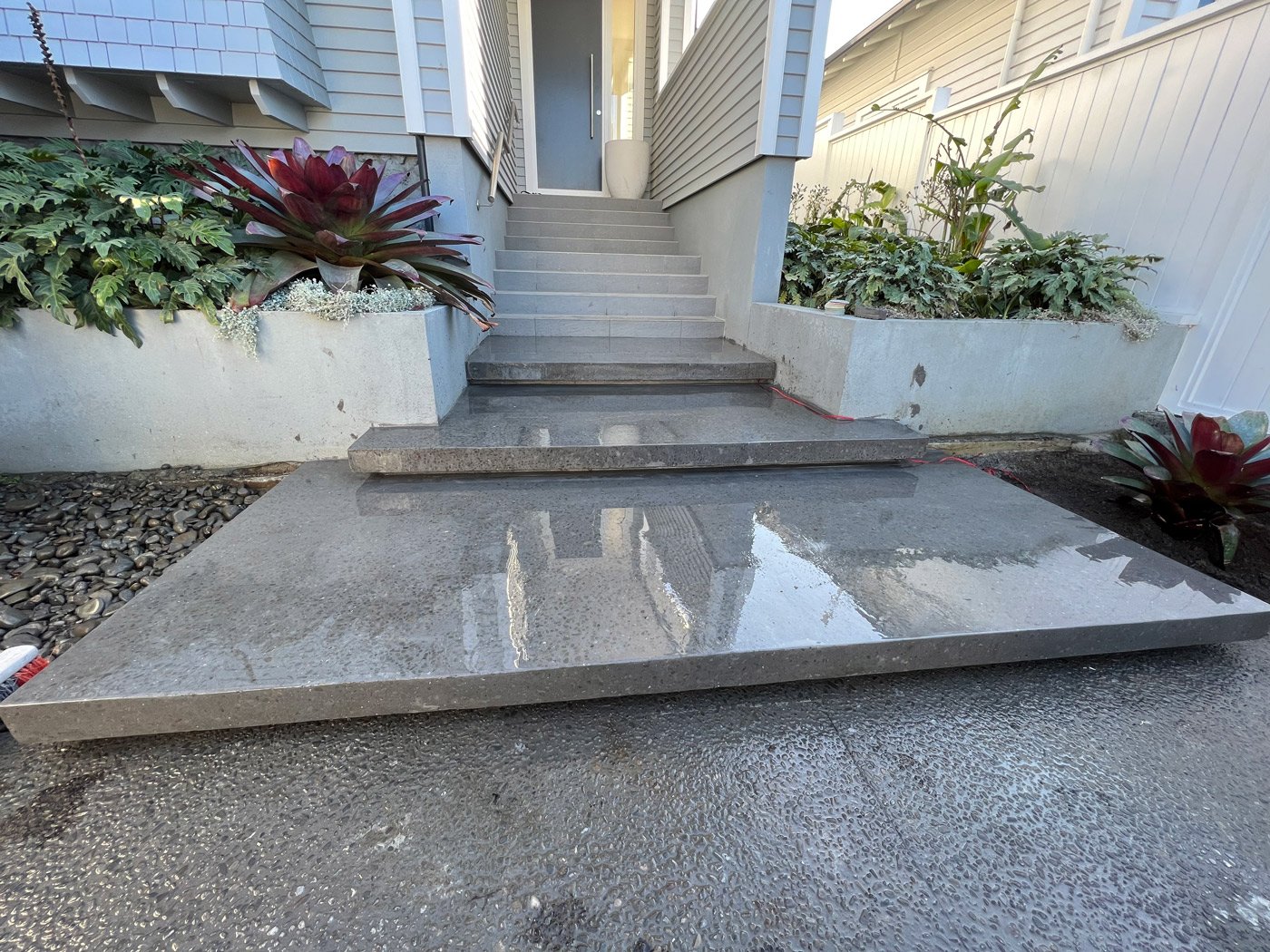 Freshly cleaned floating concrete front steps to a house