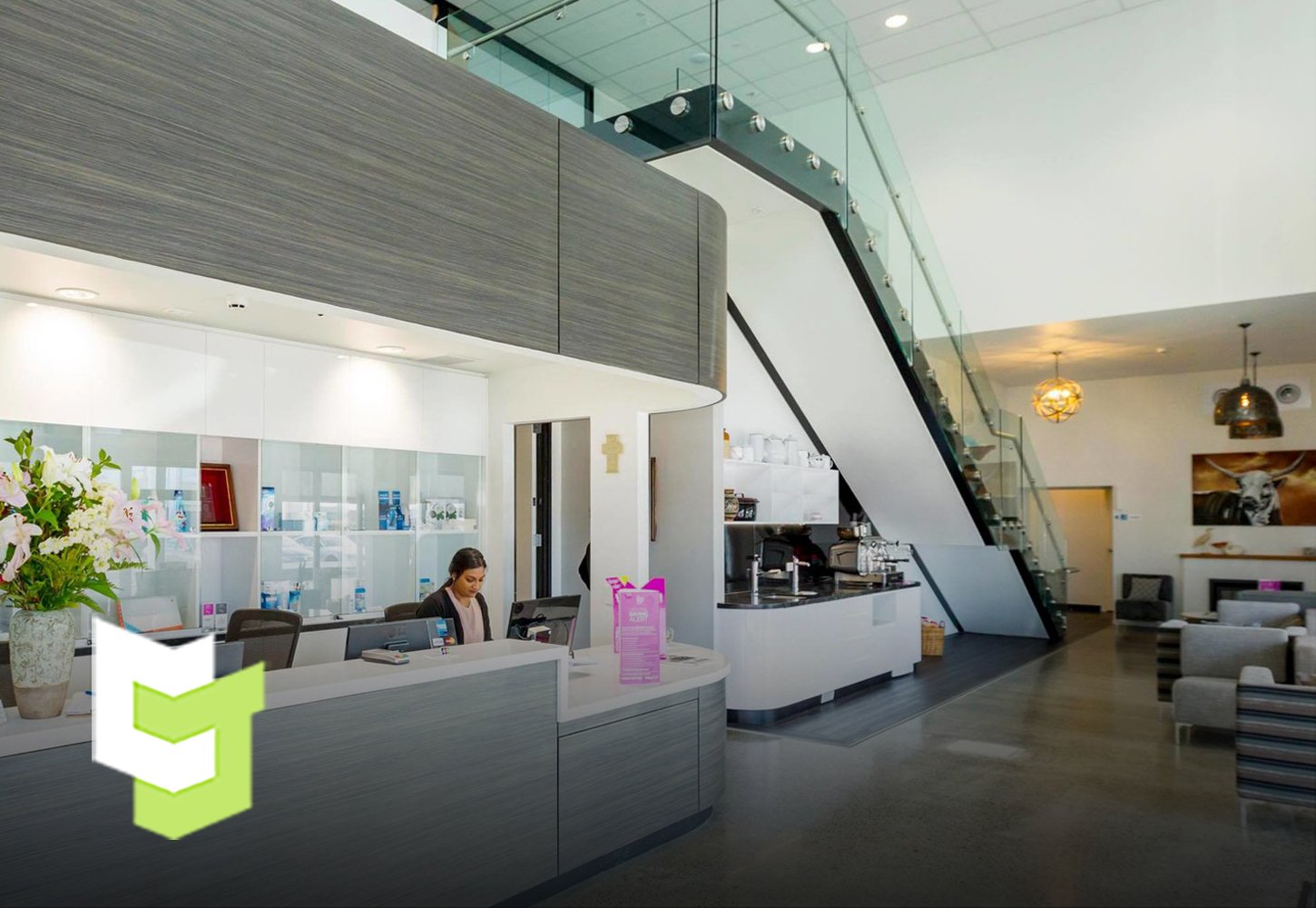 Hotel reception with white walls and ceilings and bright white lights, well-contrasted with Colourform Joinery's grey wood panels