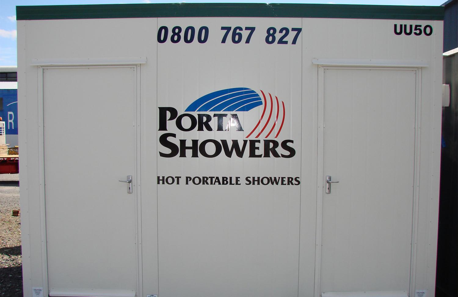 Porta Showers branded portable shower cubicle painted in white with two doors and contact number in large black letters