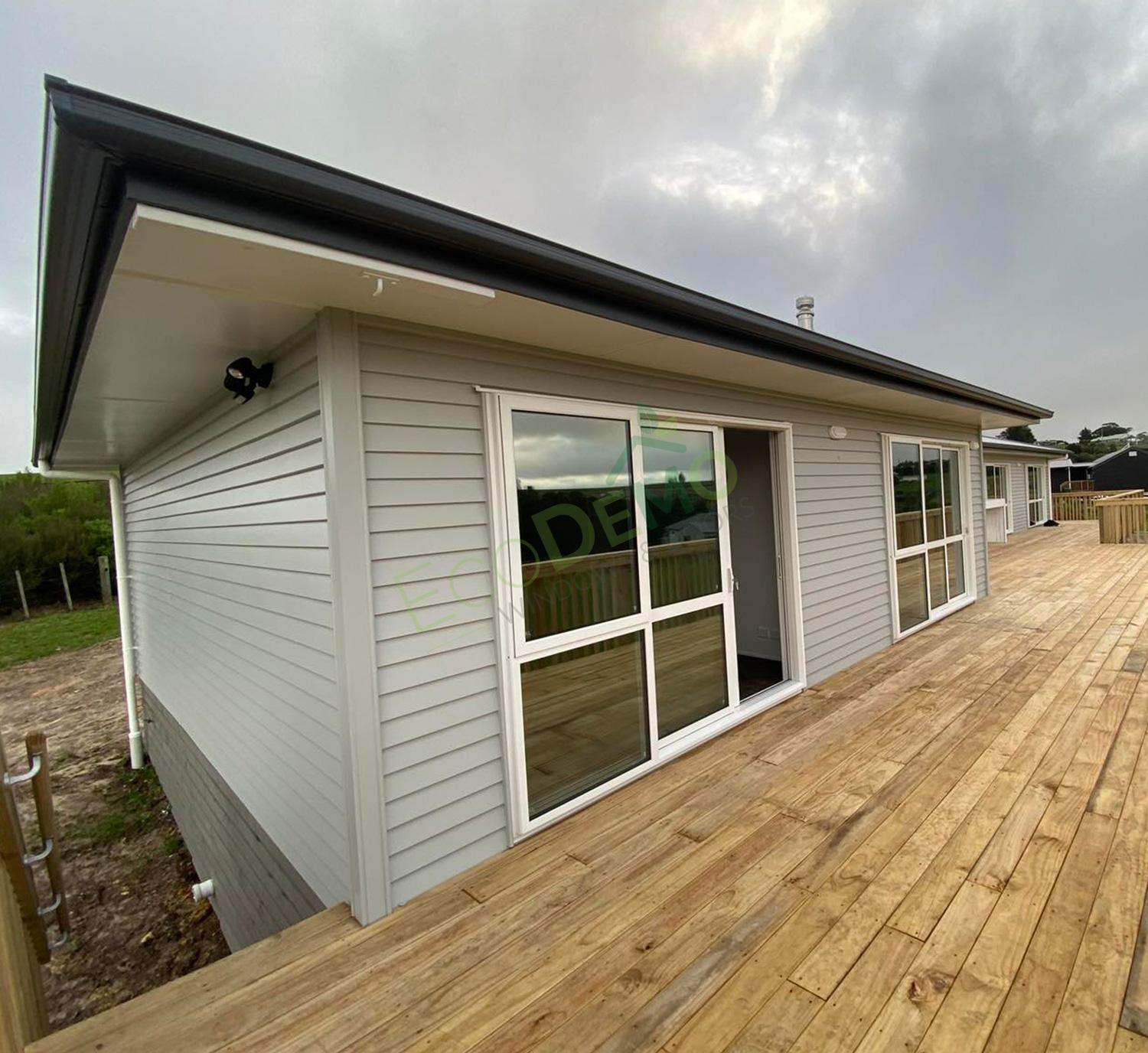 The outside of a new home and deck with white aluminium doors - linking to the aluminium door profiles page