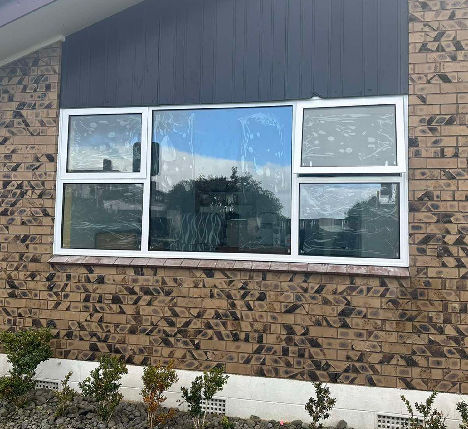 The outdside of a Brick House with White Aluminium windows - links to Aluminium Window Profiles page