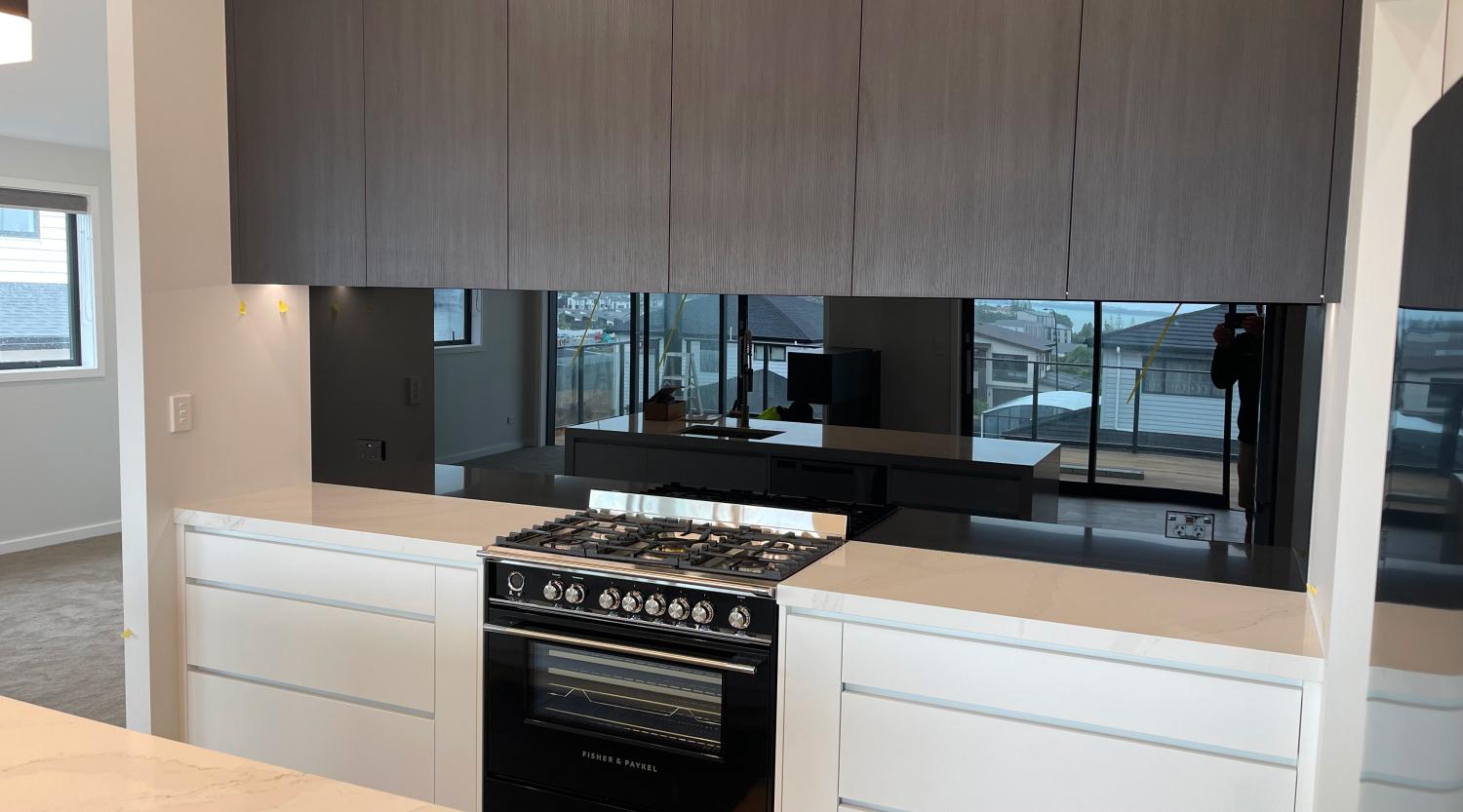 Modern kitchen with a dark glass/mirrored splashback on the back wall - links to the Glass Splashbacks / Mirrors page