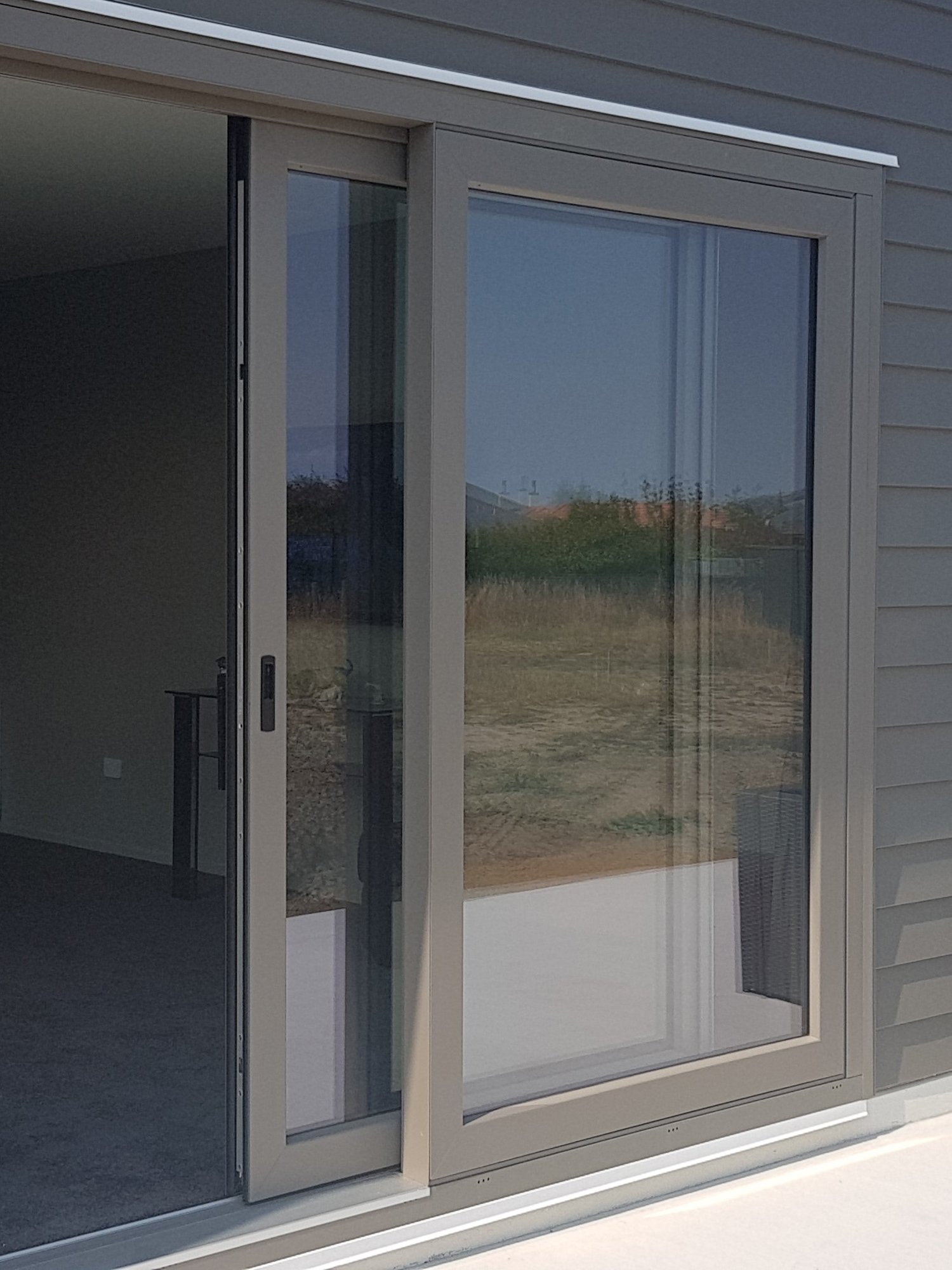 Grey weatherboard home with a large sliding door that has matching grey uPVC framing