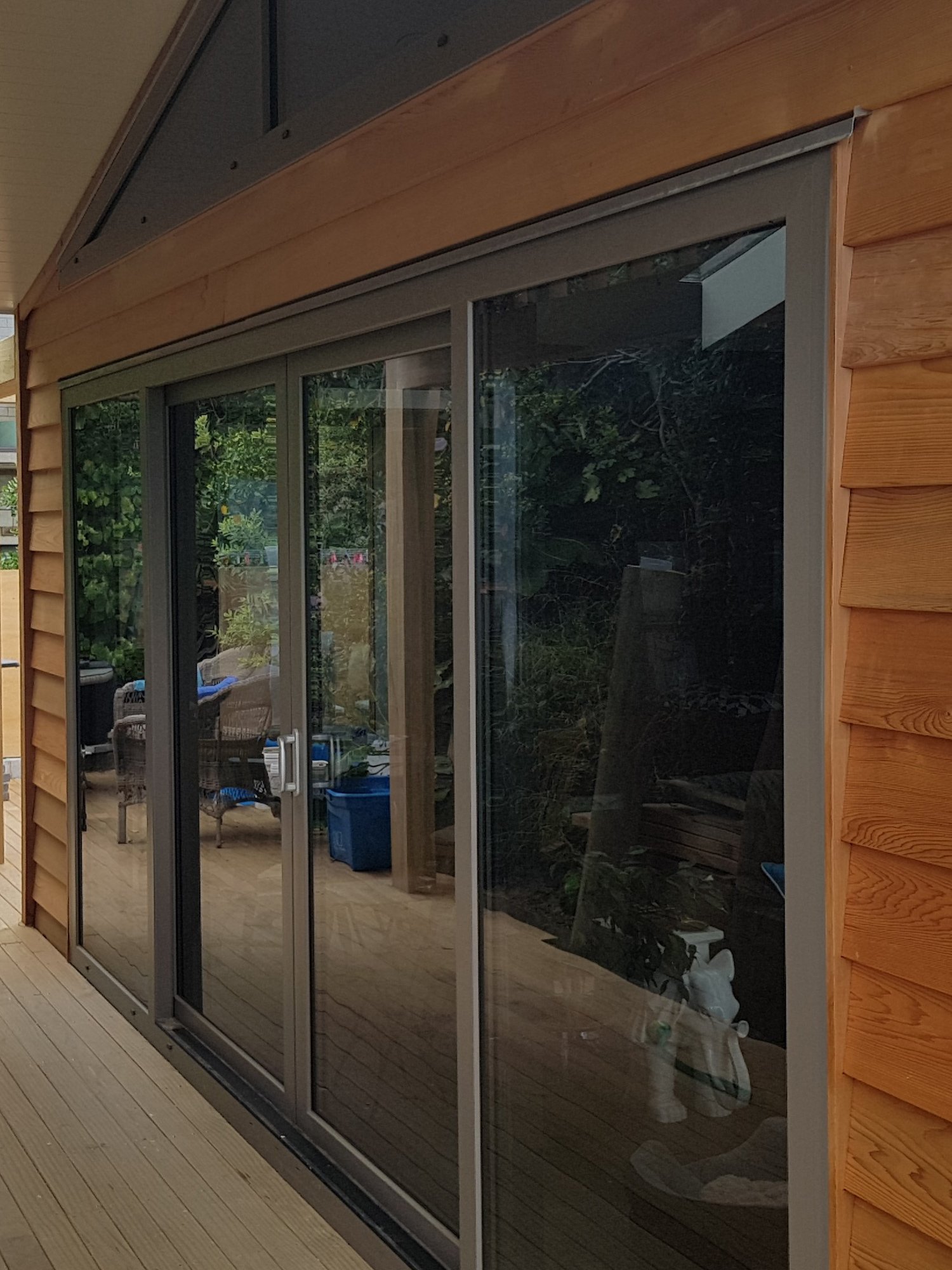 Brown weatherboard house with a grey upvc framed sliding door