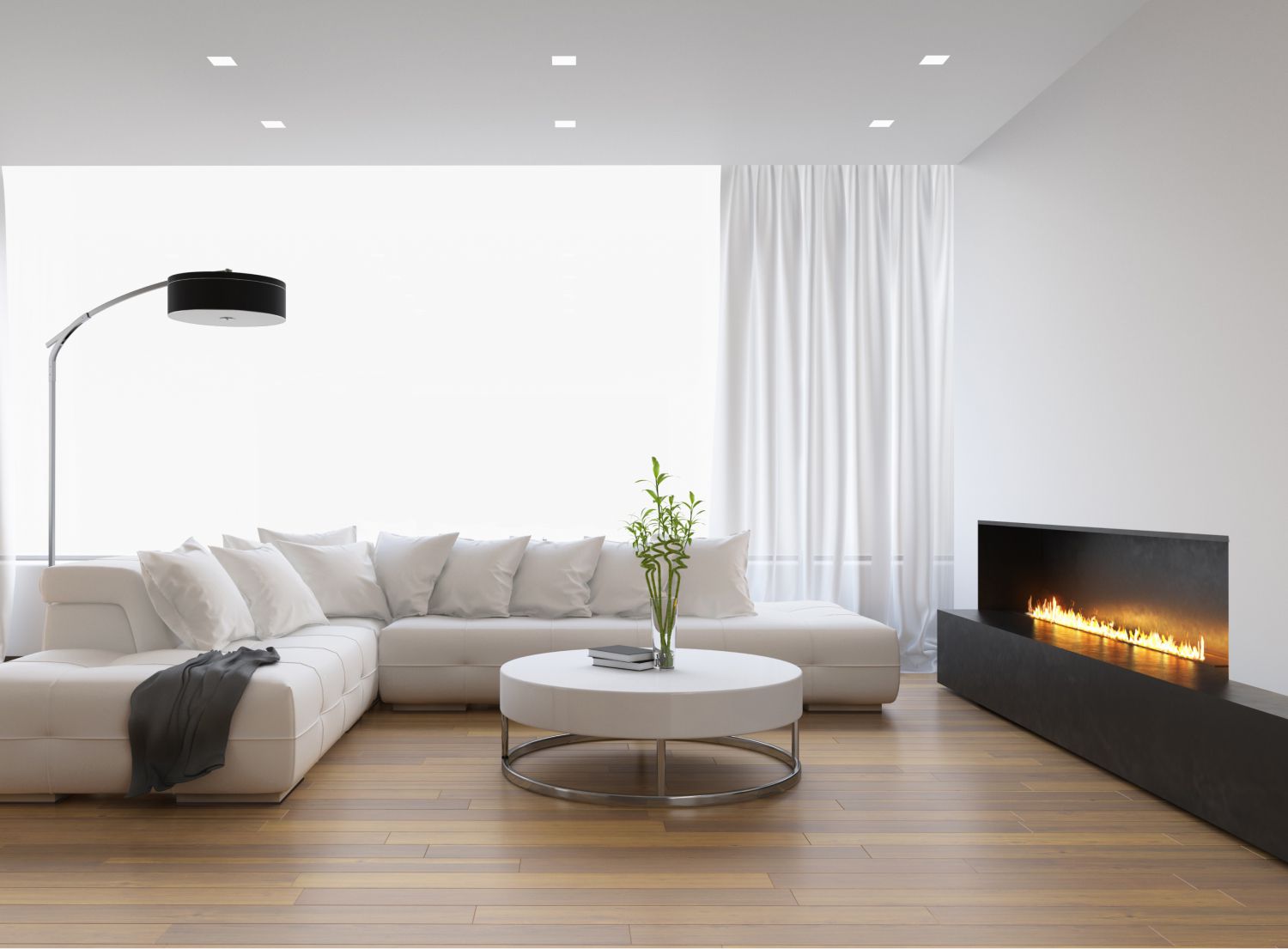 Elegant white couch in a wooden-floored living room with a warm in-built gas fire