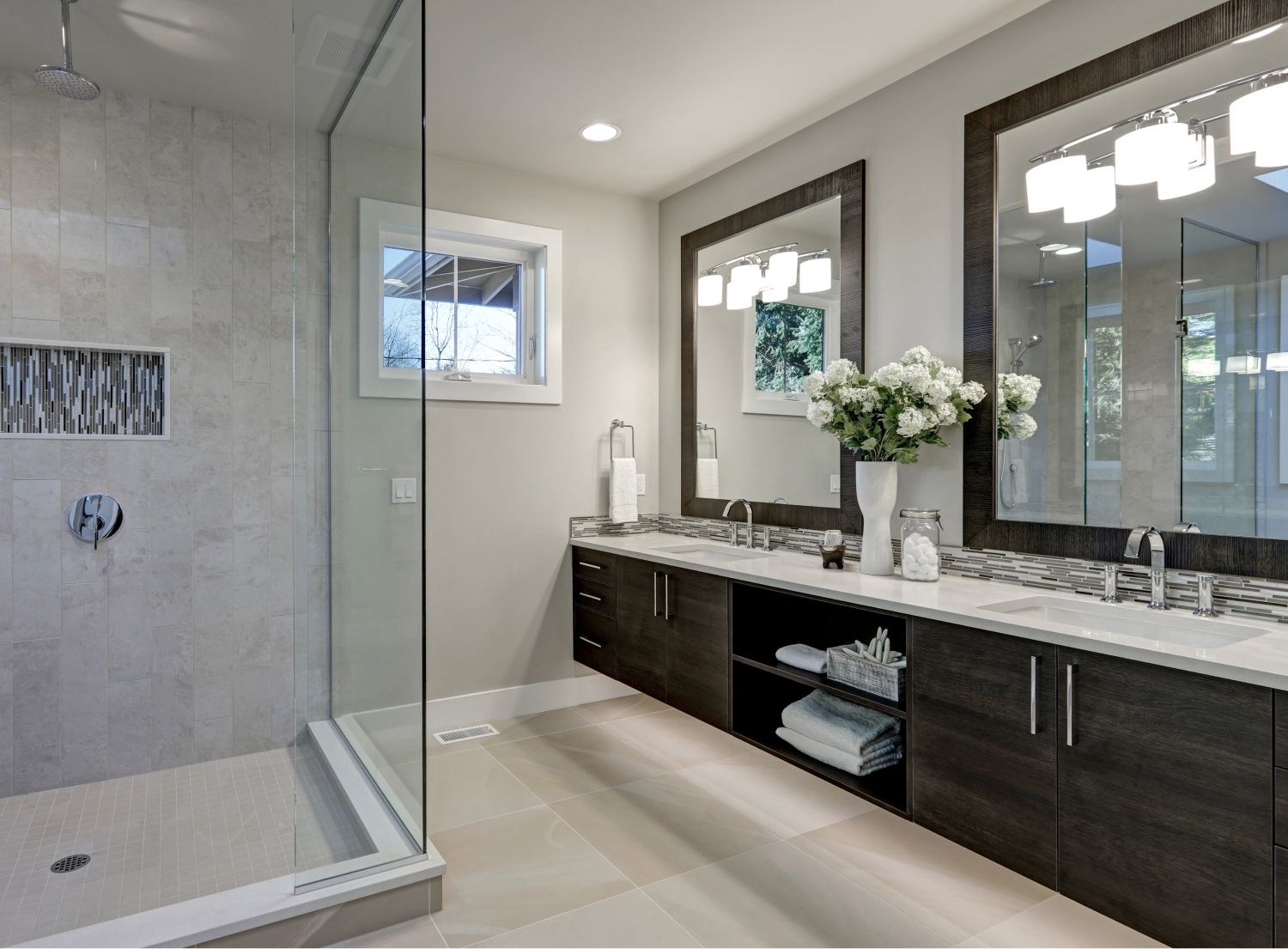 Fancy his and hers bathroom with two massive mirrors and a large open shower