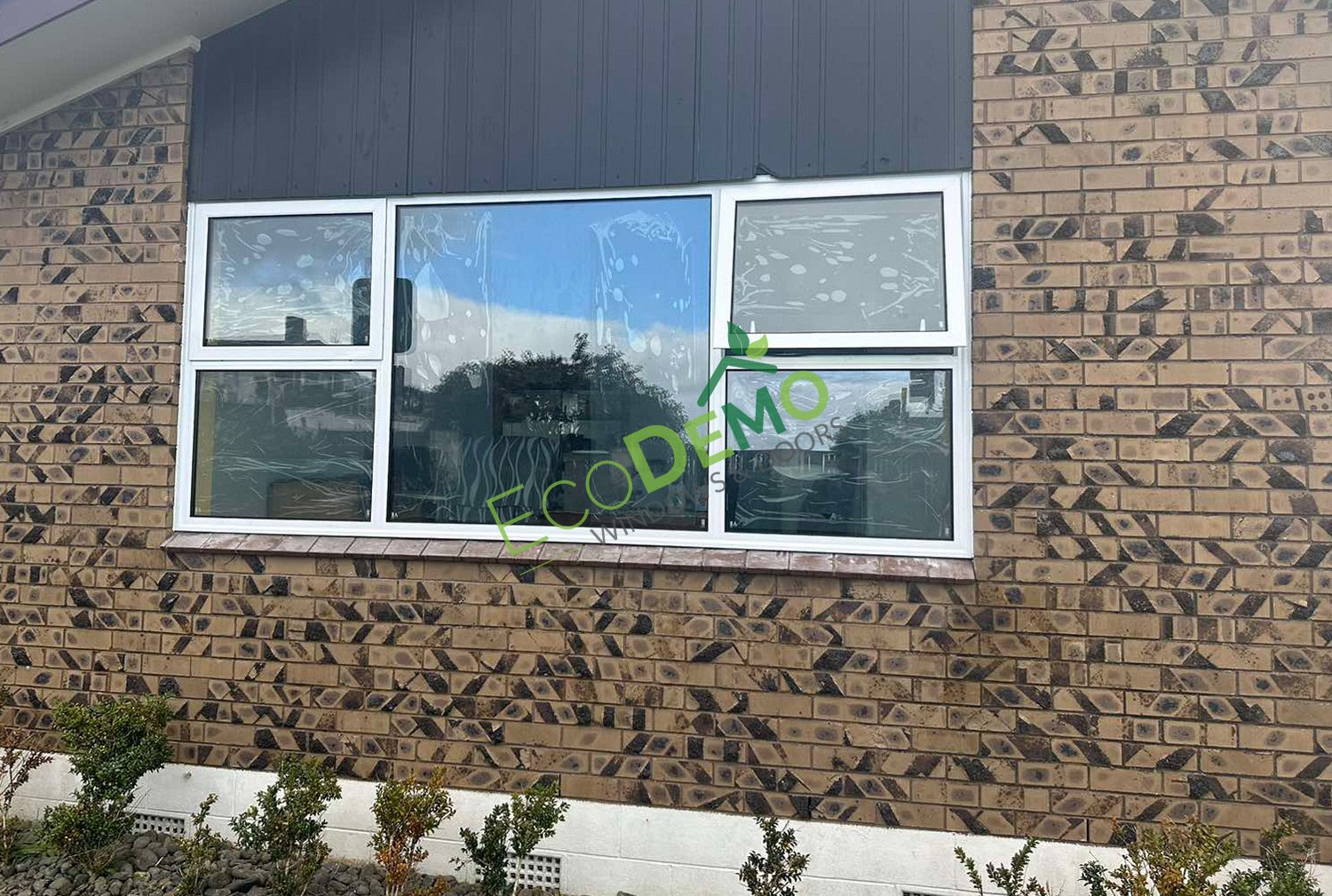 The outdside of a Brick House with White Aluminium windows - links to Aluminium Window Profiles page