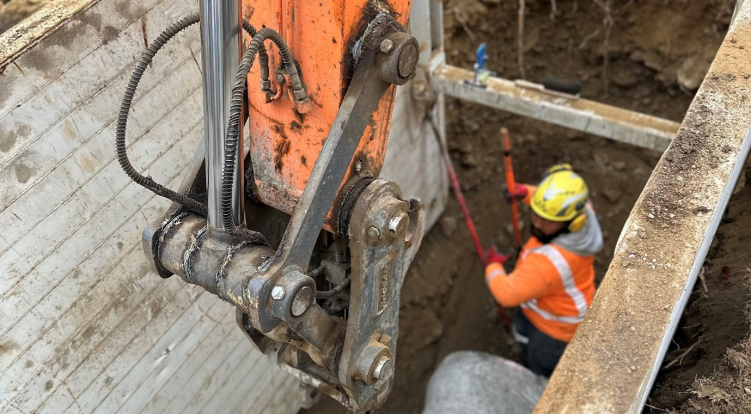 View looking down on a man in high vis and a hard hat in the ground | Drainlaying Manawatu