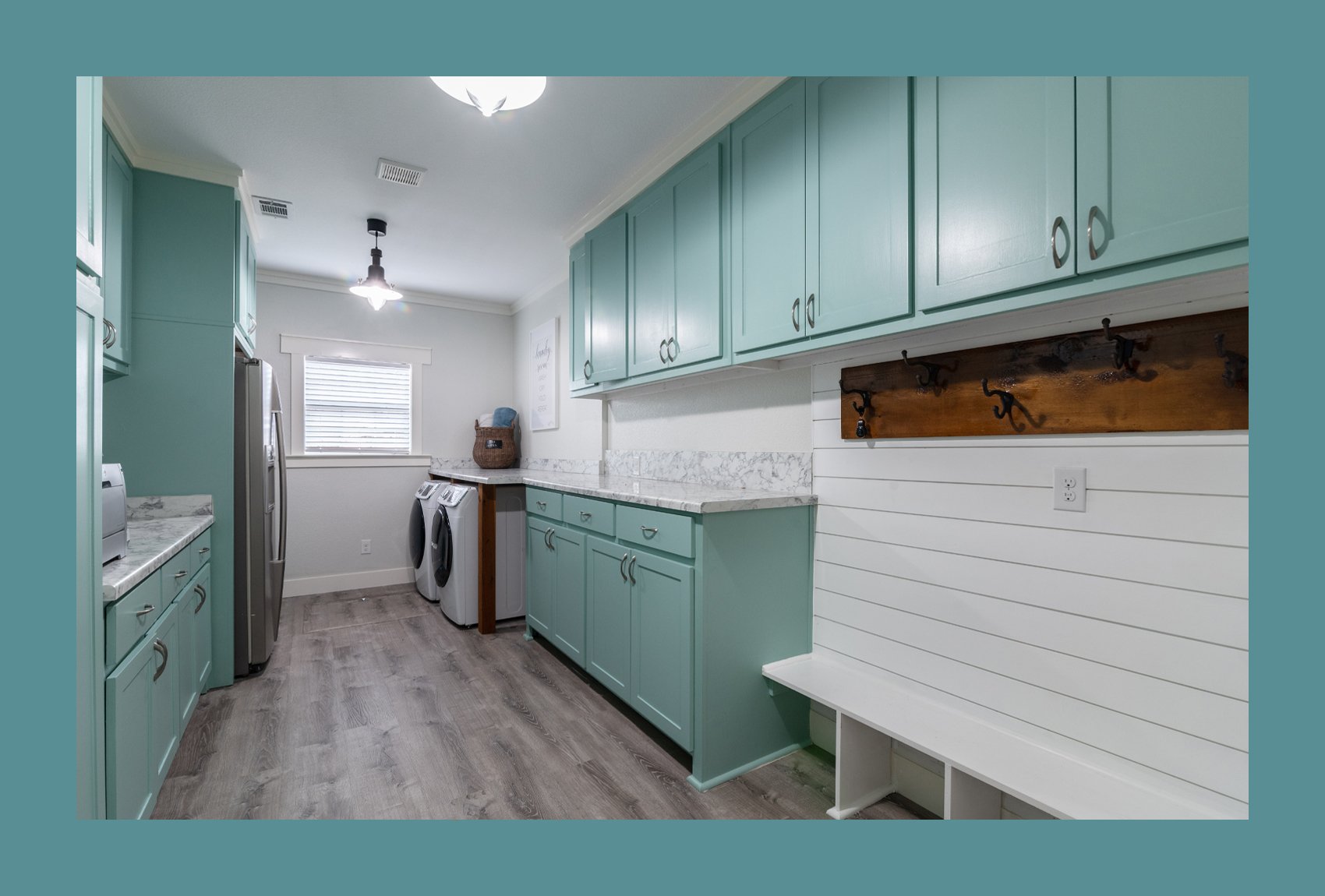 Prominent Turquoise cabinetry and white marble benchtops in a combined kitchen-laundry room