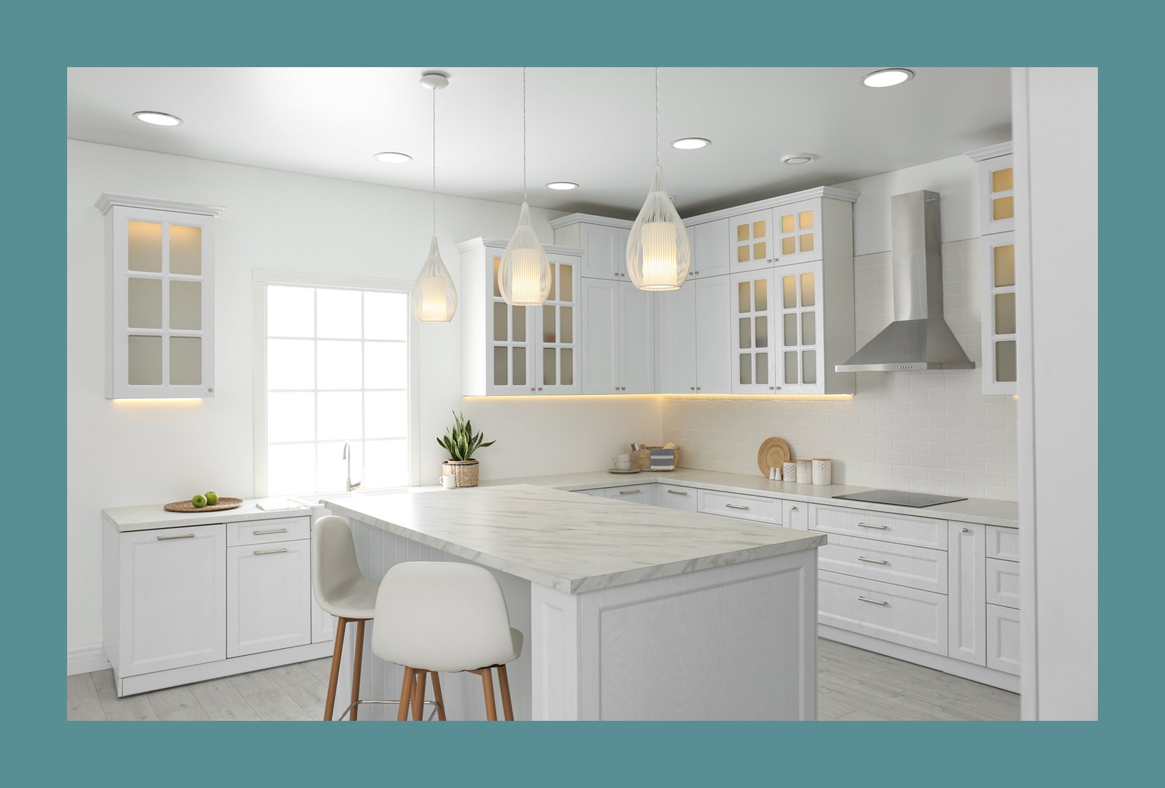 Clean all-white kitchen with fancy hanging lights and a nice marble island sitting area