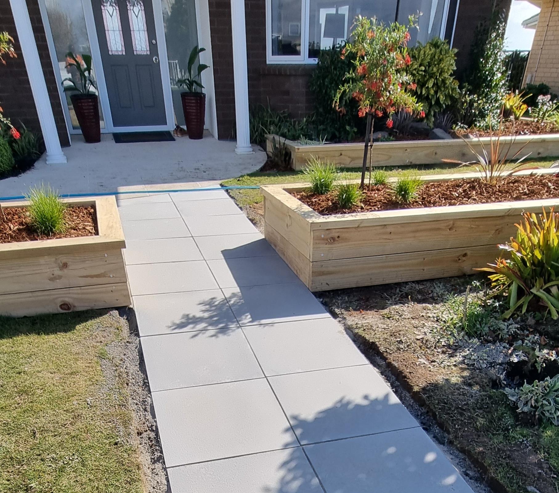 paved path leading between raised gardens