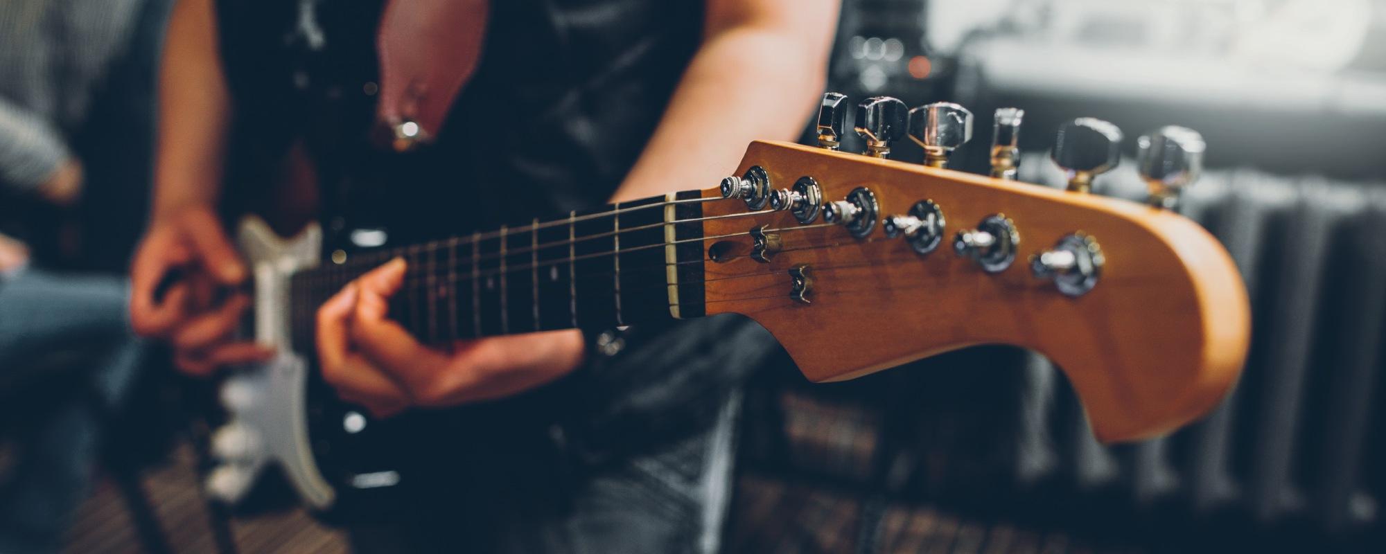 Music teacher playing a tune on an electric guitar