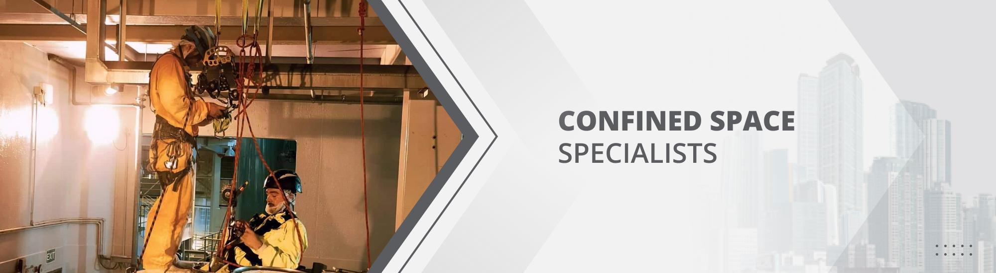 Two abseilers in their harnesses on top of a cylinder, maintaining the tank in a very confined space