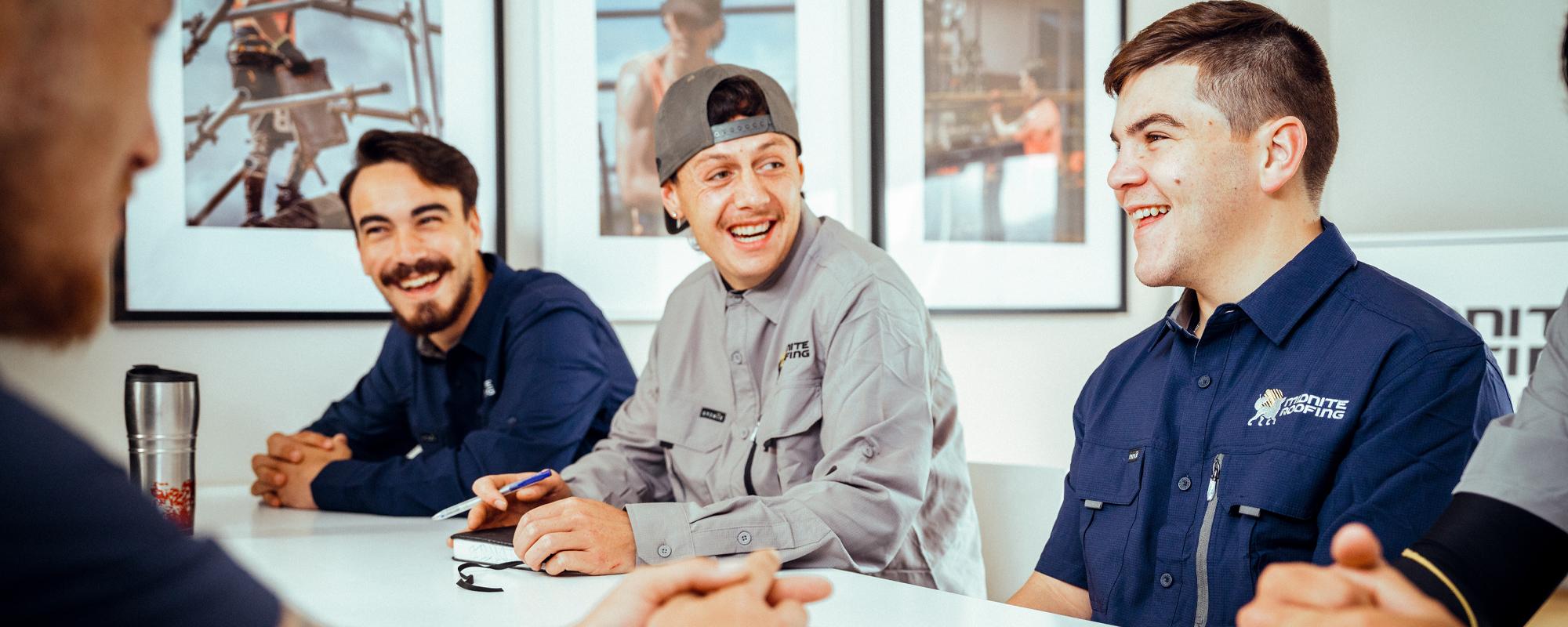 Four of Midnite roofings young apprentices sitting around a table have a chat and a laugh