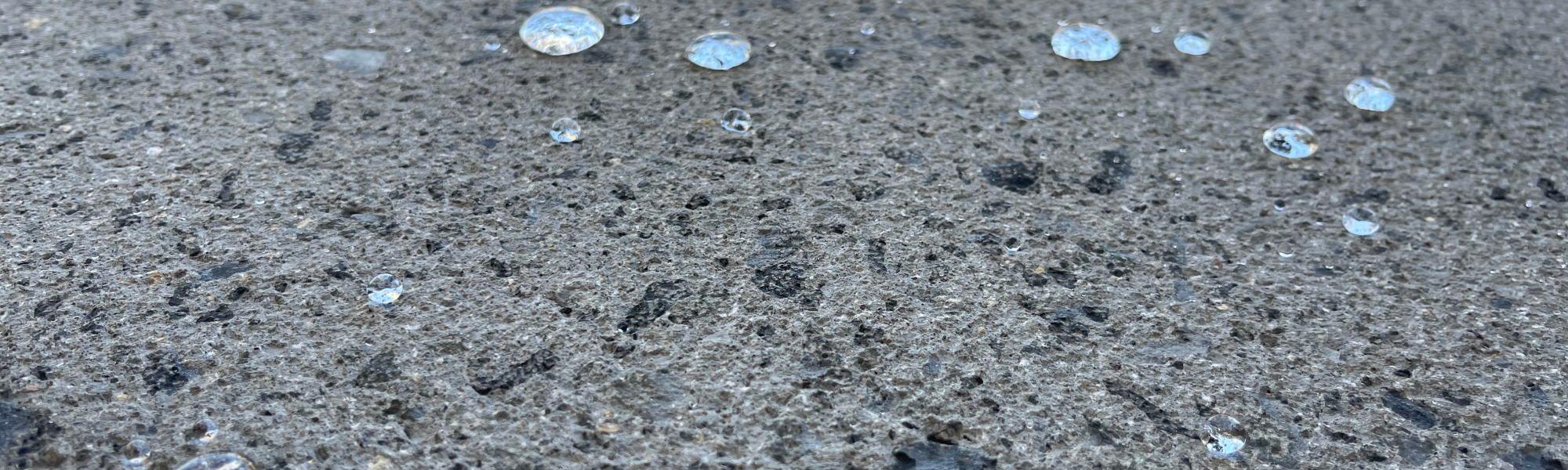 Textured concrete showing its water repellant ability as droplets form on top 