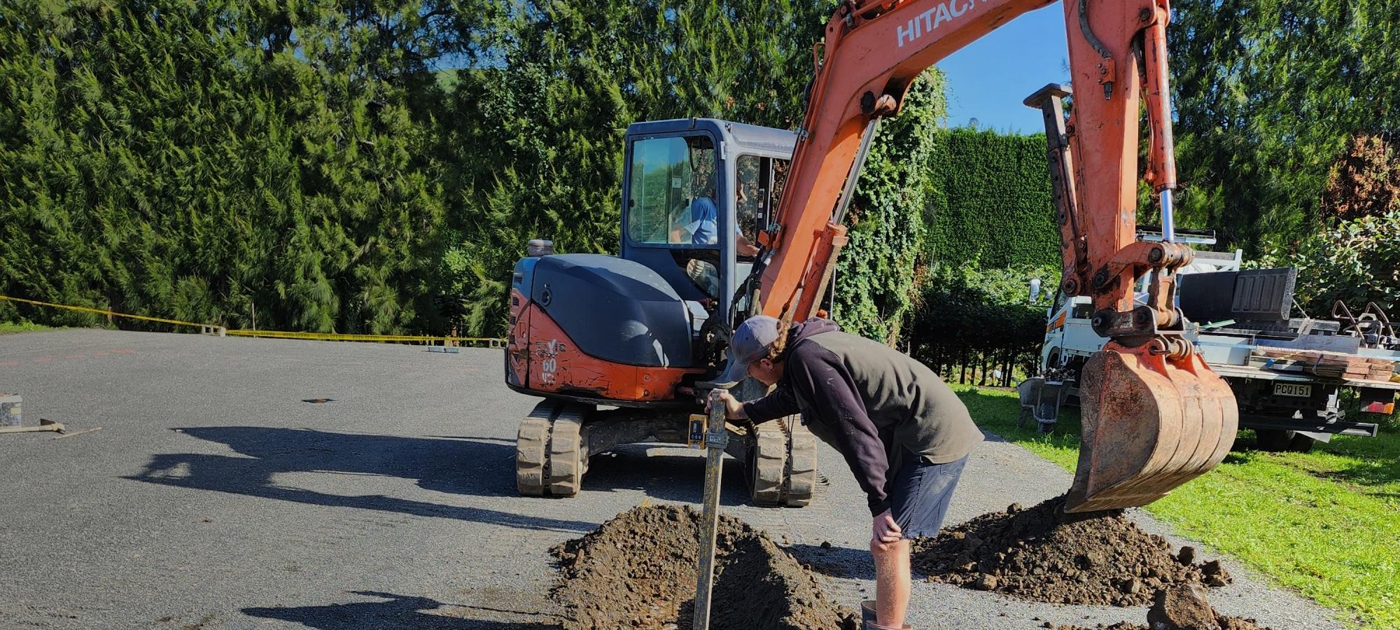 small Orange hitachi digger behind a gray banner