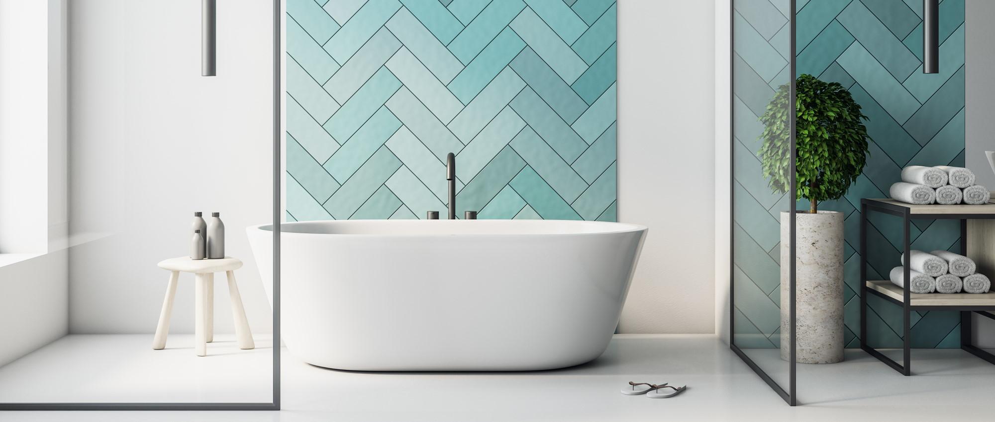 Inviting hotel-like bathroom with an enormous white bathtub, blue tile wall designs, and clean minimalistic bathroom furniture