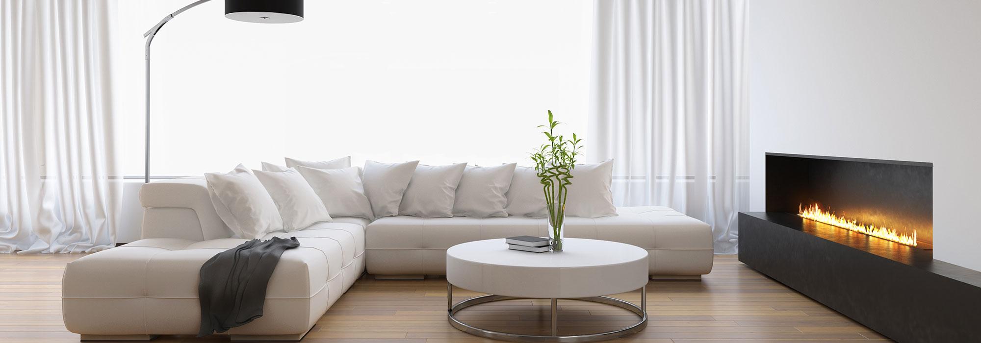 Elegant white couch in a wooden-floored living room with a warm in-built gas fire