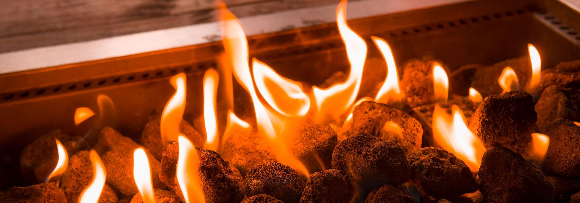 Burning black coals with hot orange flames in the middle of a gas fireplace