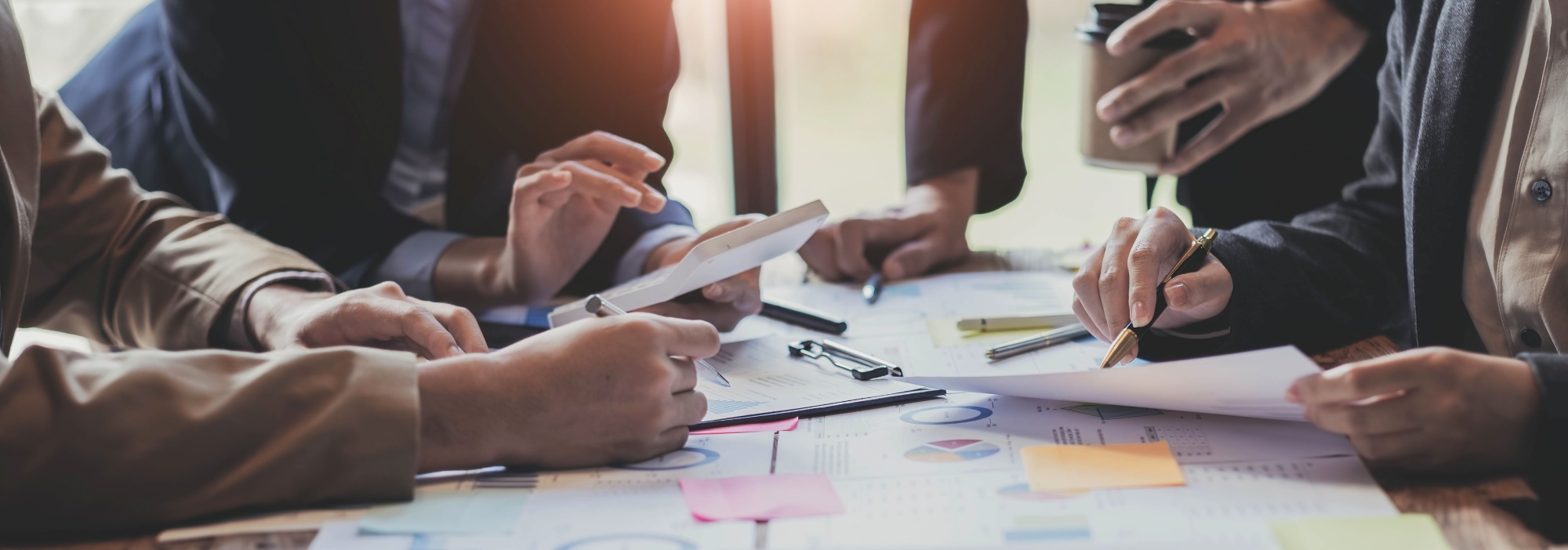 XO Recruitment specialists collaborating and planning with clipboards, calculators, and lots of paper